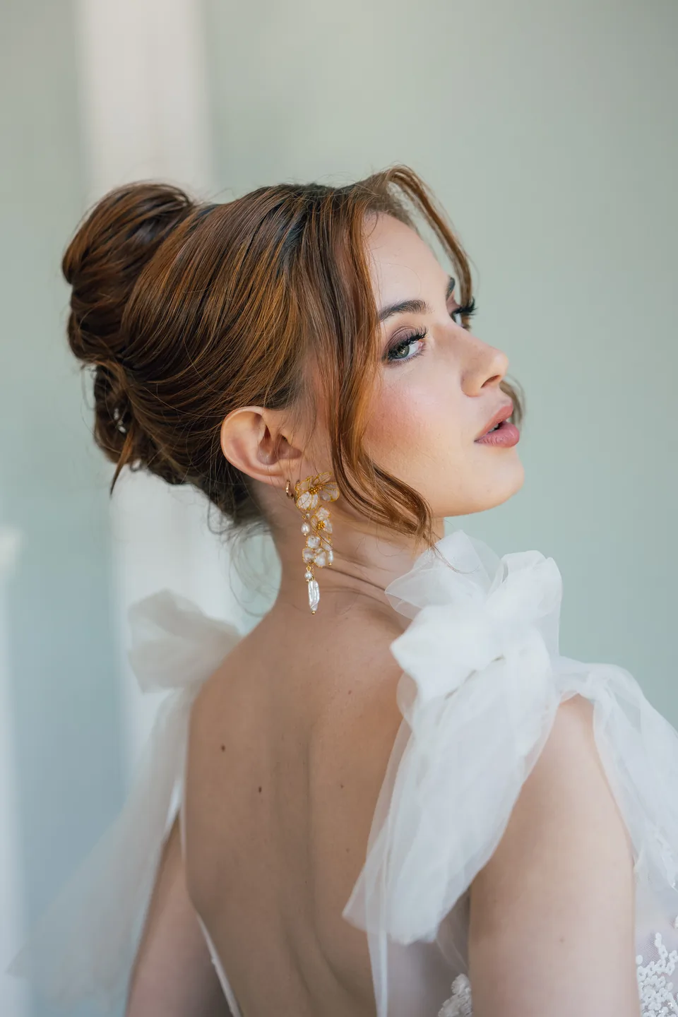 Une mariée portant des boucles d’oreilles florales